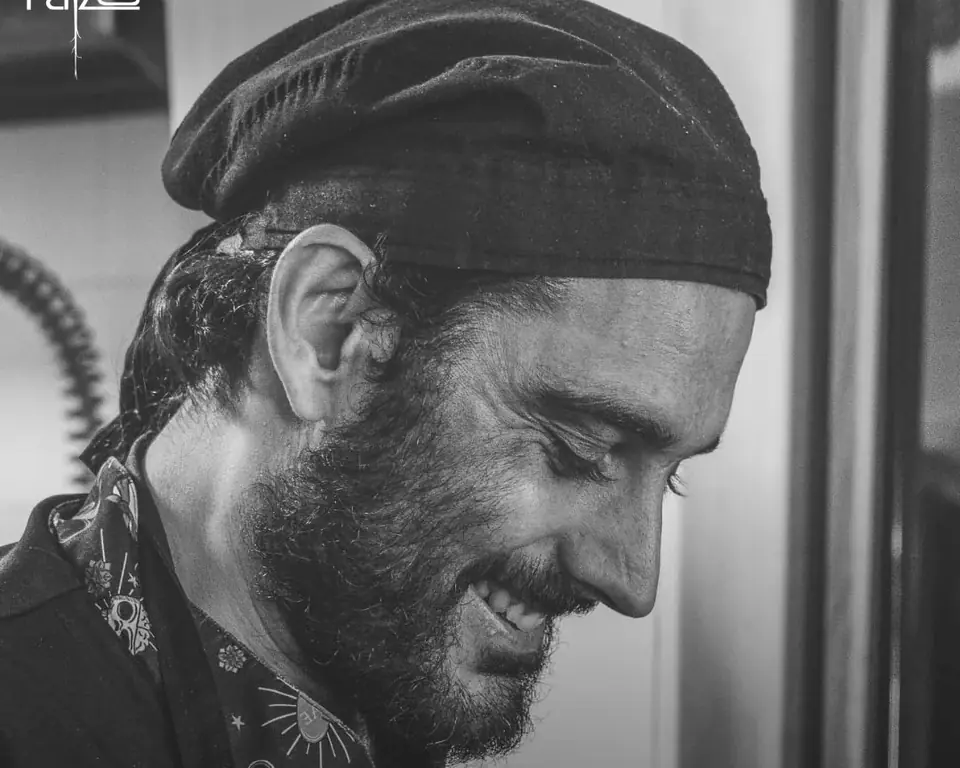 Retrato en blanco y negro de un cocinero de Raizes sonriendo
