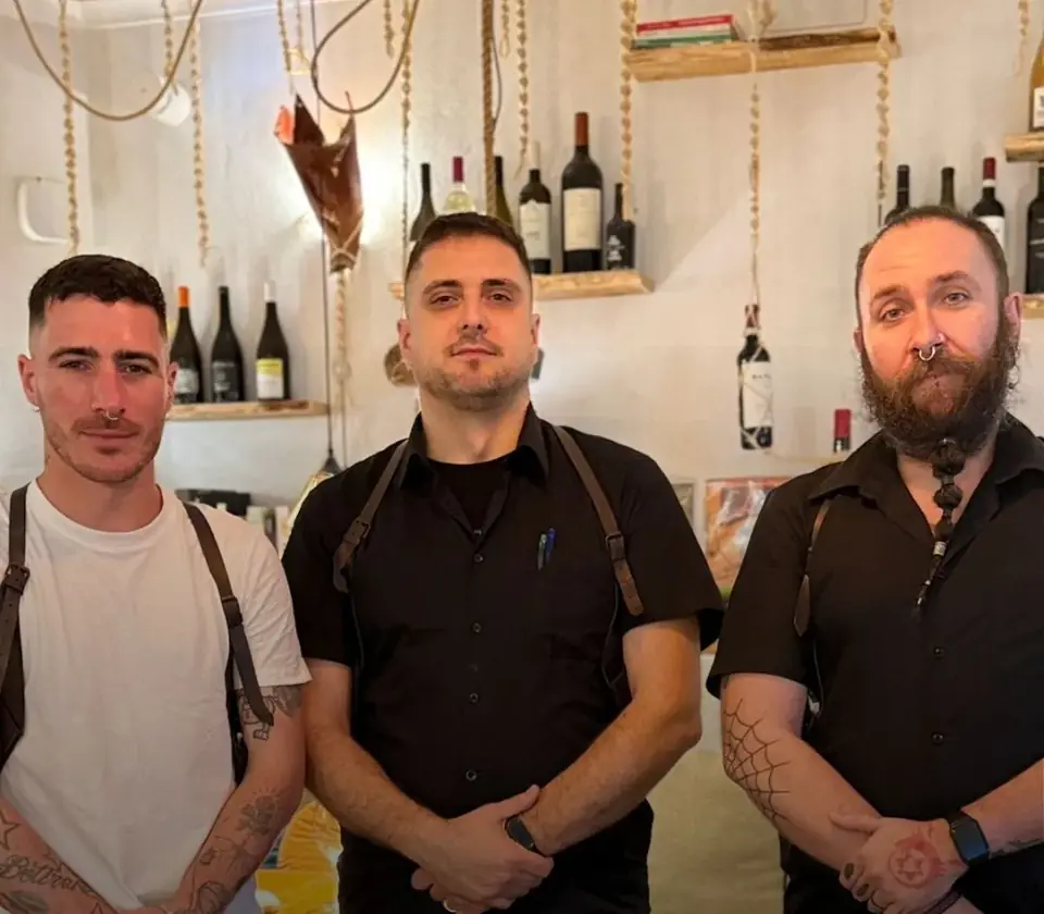 Tres miembros del equipo de sala de Raizes junto a la bodega